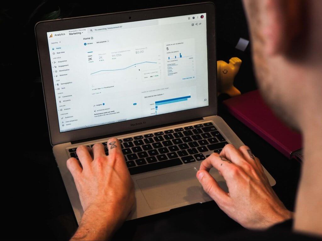 Male typing on a laptop open to data on Google Analytics