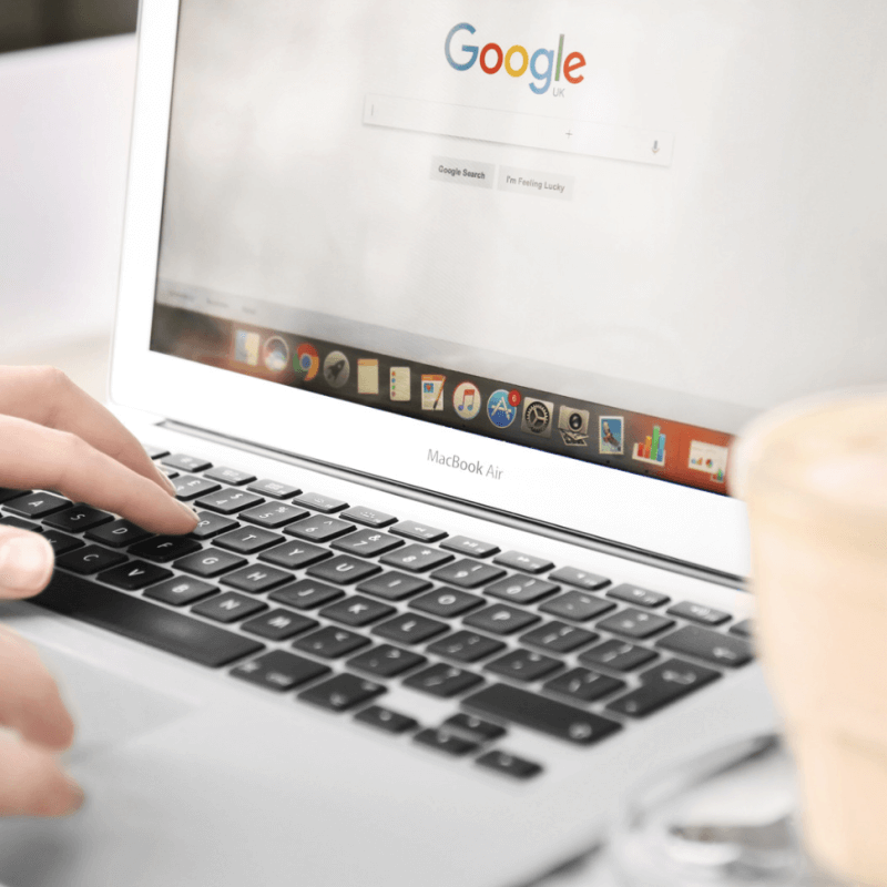 Hands typing on a laptop with a Google Search Page on the screen | Ideal SEO Checklist